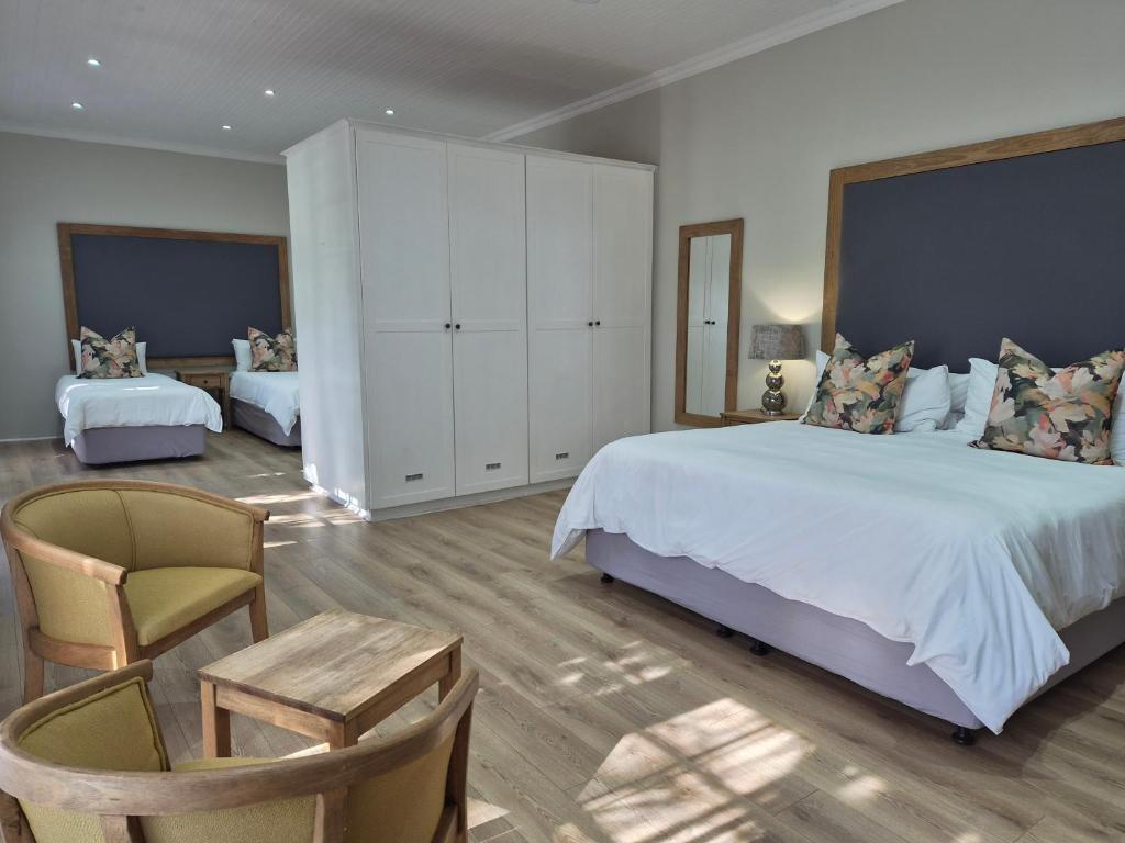 a large bedroom with a large bed and a chair at Milner Manor in Grahamstown
