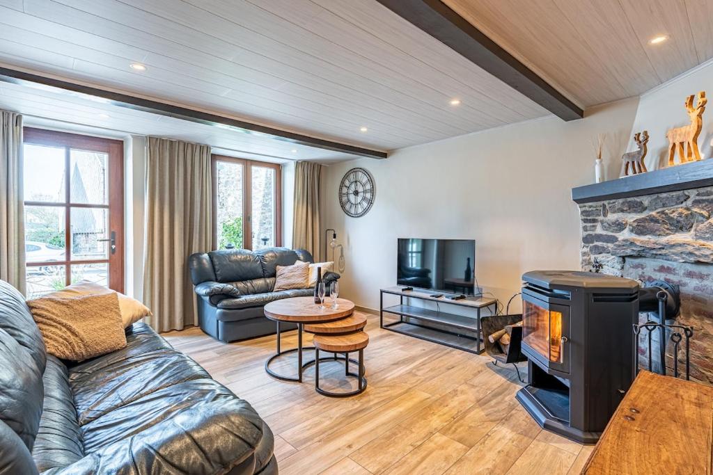 a living room with a couch and a fireplace at Le charron in Bièvre