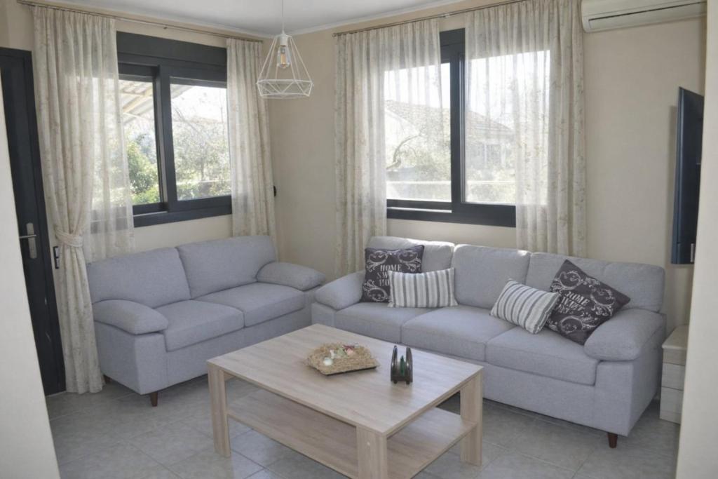 a living room with a couch and a coffee table at Arethousa House in Nea Vrasna