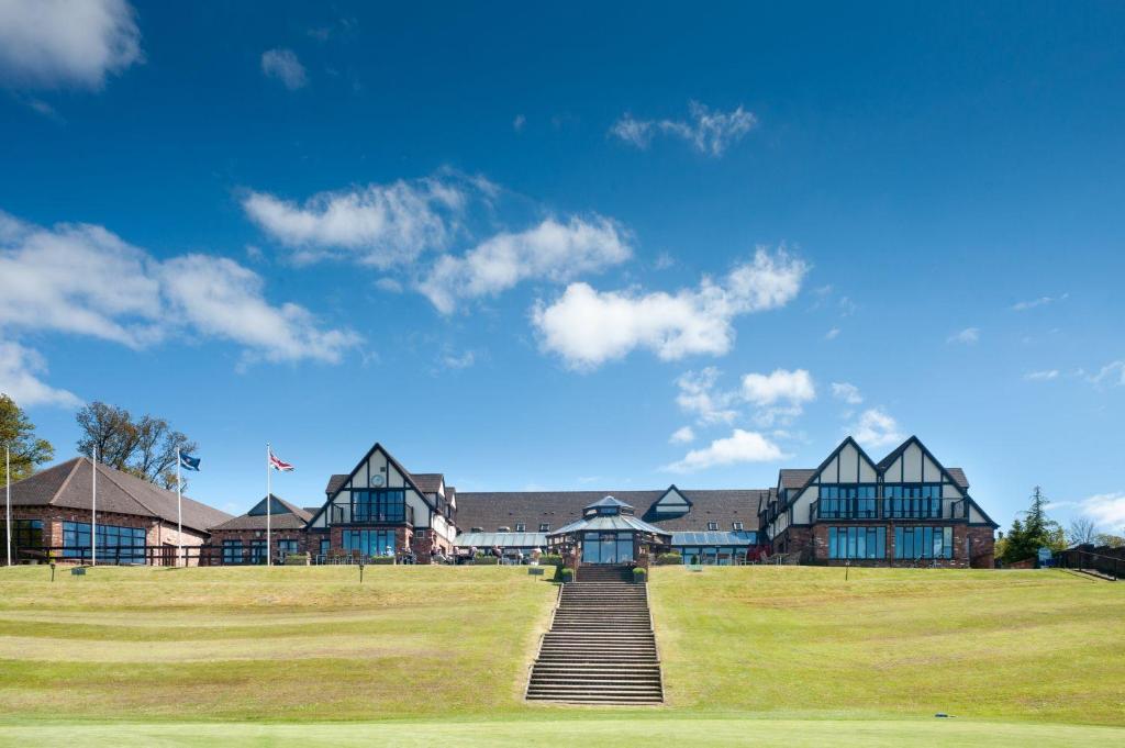 a large building with a staircase in the middle of a field at Woodbury Park Hotel & Spa in Exeter