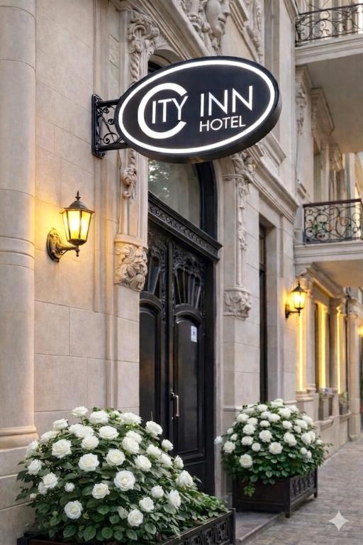 a hotel sign on the side of a building with flowers at Baku City Inn Boutique Nizami Hotel in Baku