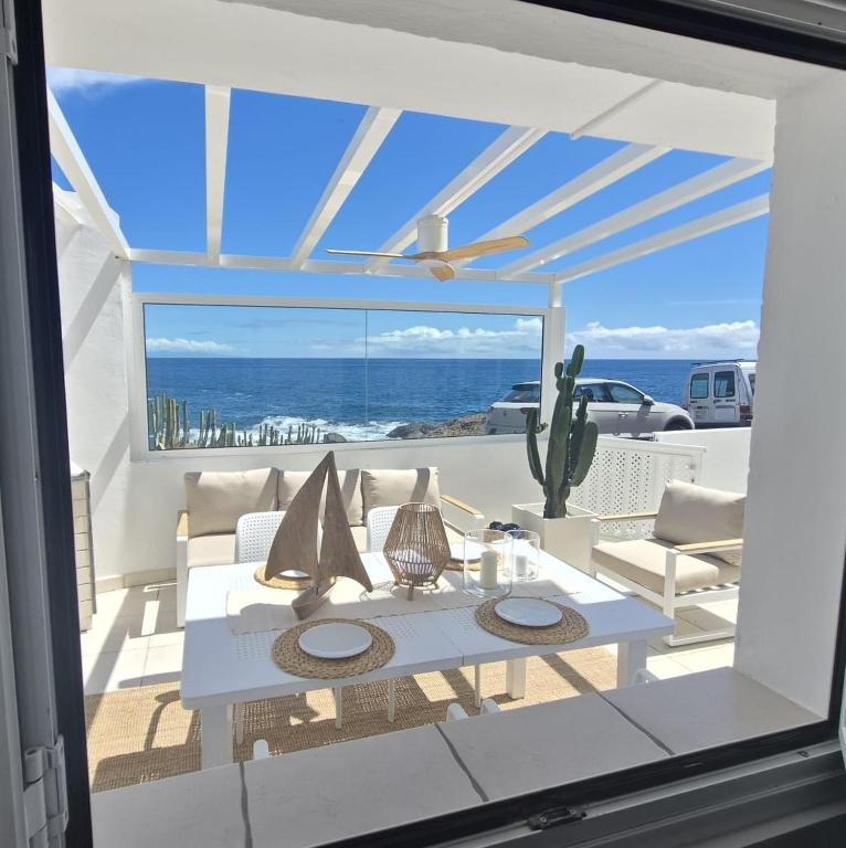 a living room with a table and a view of the ocean at Lodges Tenerife in La Mareta