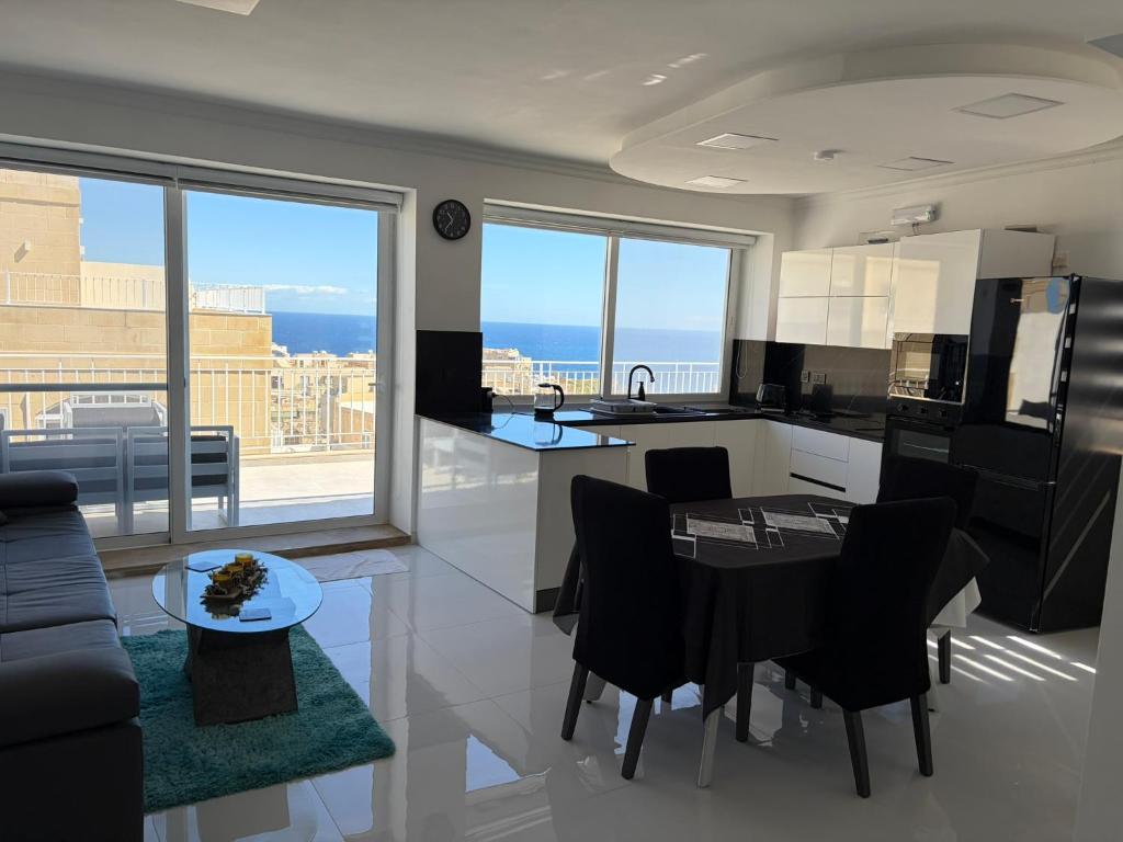 a kitchen and living room with a view of the ocean at Welcome Apartment 13 in Għajn Melel
