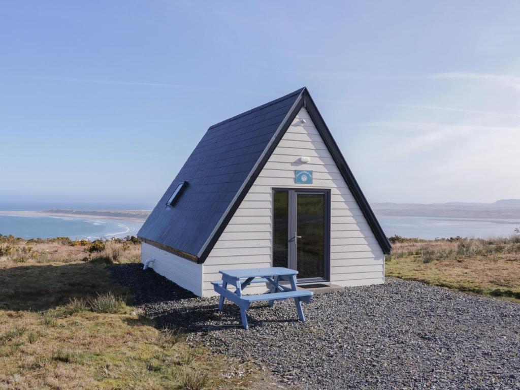 a small house with a blue bench in front of it at Cabin 2 Min Larach in Gortahork