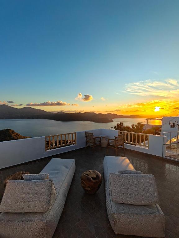 a rooftop patio with a view of the ocean at sunset at Sunset studio in Plaka in Plaka Milou