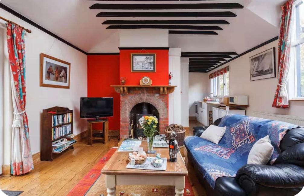a living room with a blue couch and a fireplace at Spout House Studio in Boldre