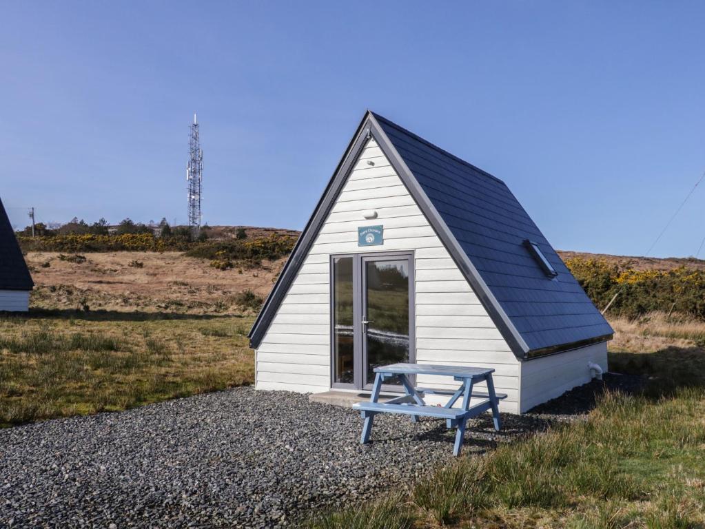 a small house with a blue bench in front of it at Cabin 4 Doire Chonair in Gortahork