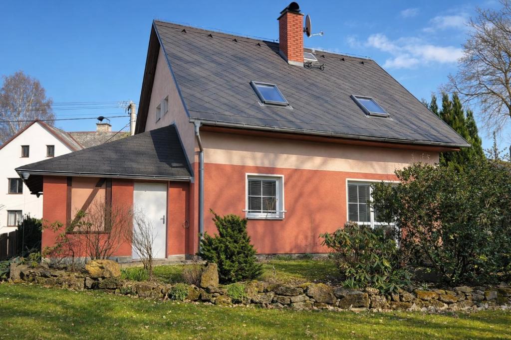 a house with a black roof at Symbiola Holiday House in Arnoltice u Decina