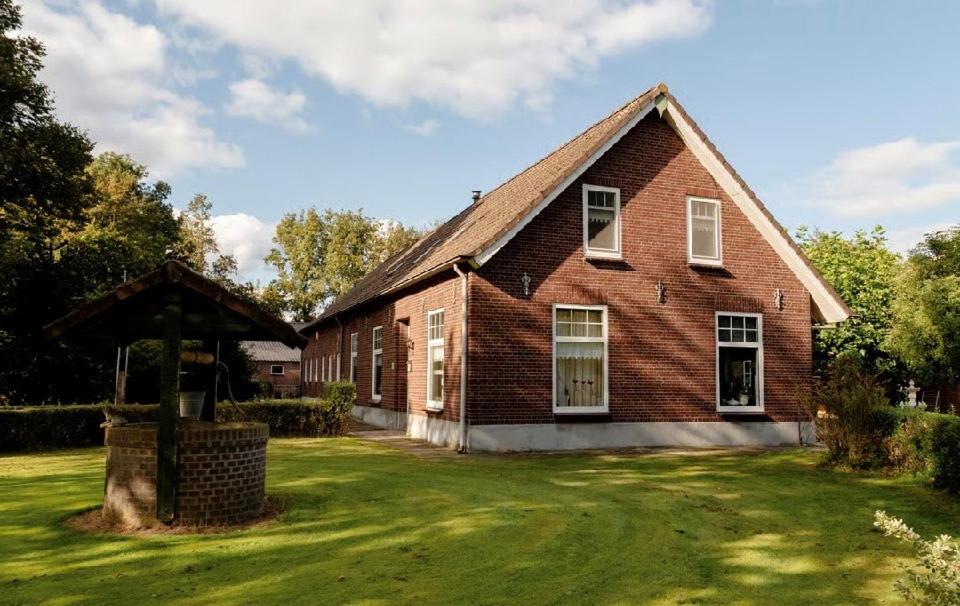 a large brick house with a grass yard at B&B Chili Hoeve in Wanroij