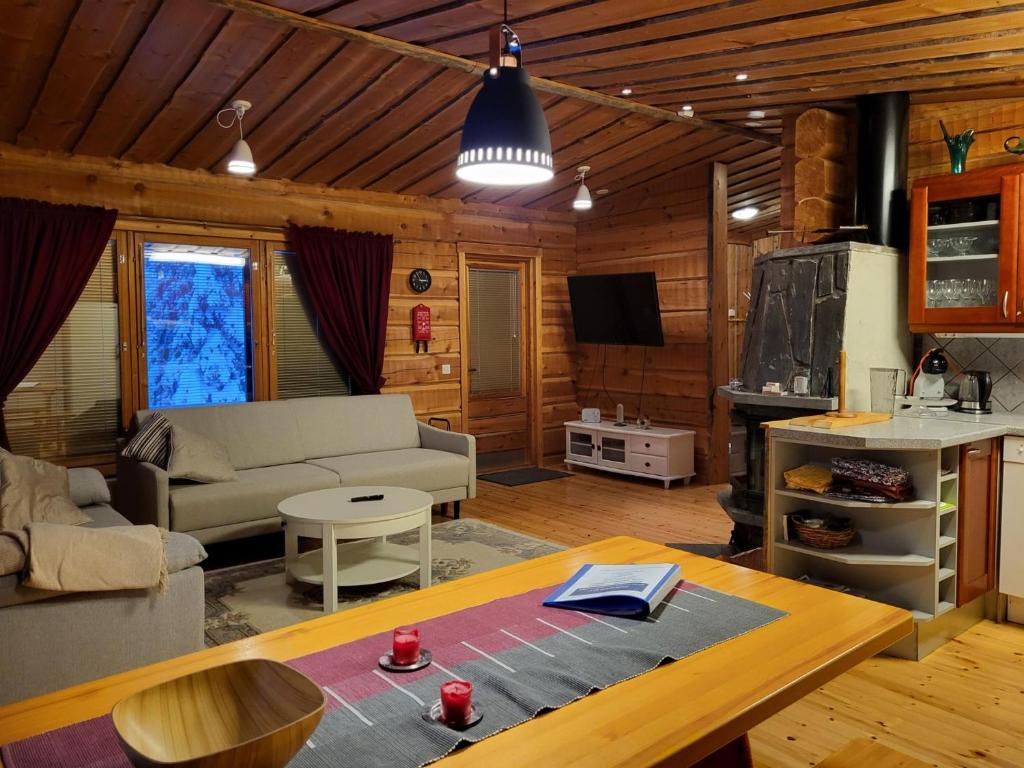 a living room with a couch and a table at Huvila Vuosselin Nuppu in Kuusamo