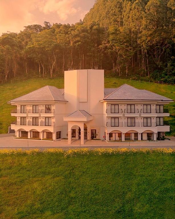 ein großes weißes Gebäude mitten auf einem Feld in der Unterkunft Hotel Cantuccio in Arroio Trinta