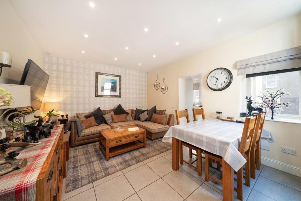 a living room with a couch and a table at Fionas Cottage in Crieff