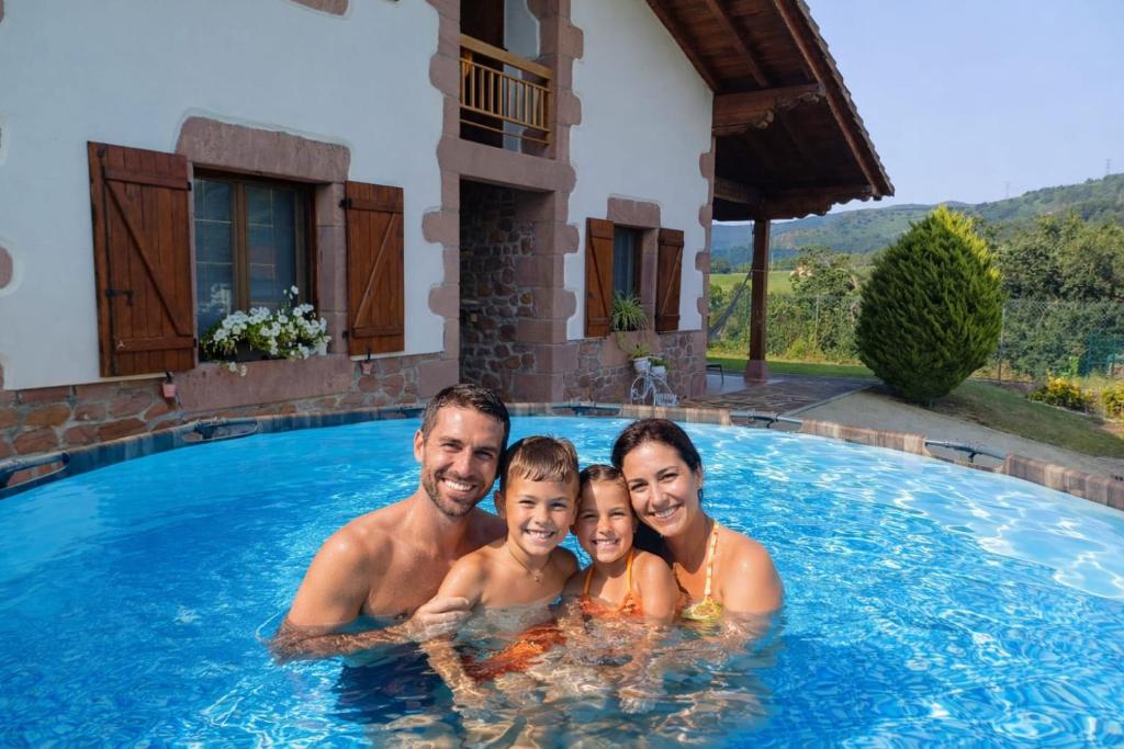 a family in the swimming pool of a villa at Casa Rural Amazonas in Sumbilla