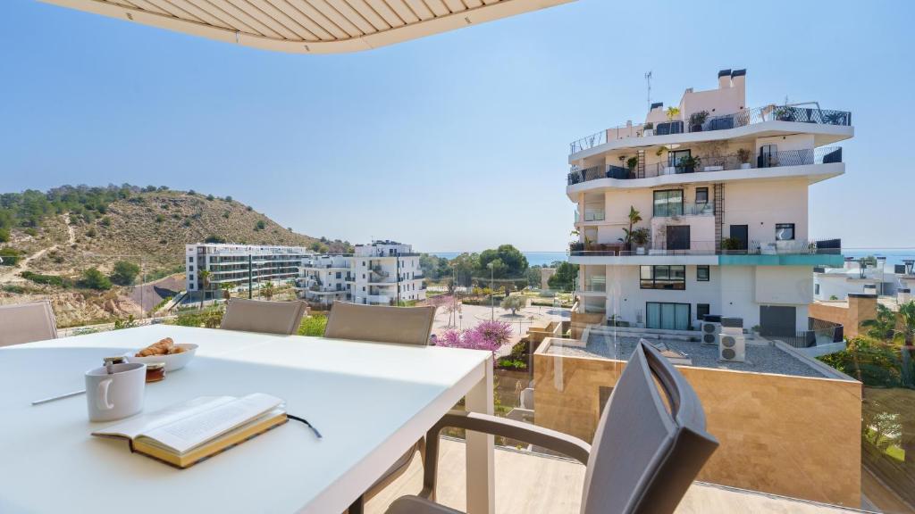 a white table and chairs with a view of a building at ALLONBAY dream apartment in Villajoyosa