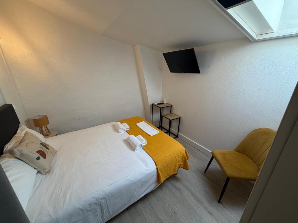 a small bedroom with a bed and a chair at Le central in Balaruc-les-Bains