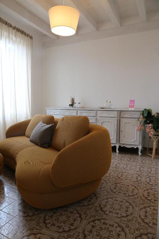 a living room with a brown couch and a kitchen at Casetta Amati 2 in Nettuno