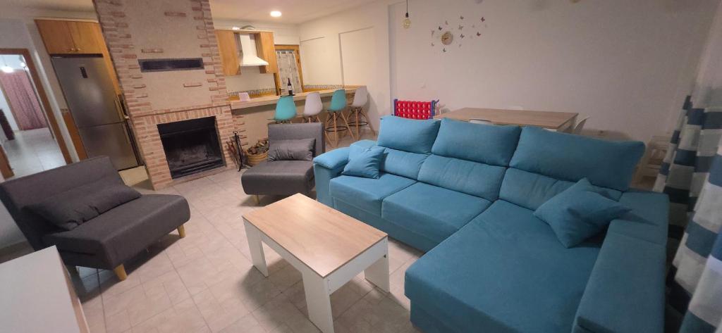 a living room with a blue couch and chairs at Atardecer dorado in Ruidera