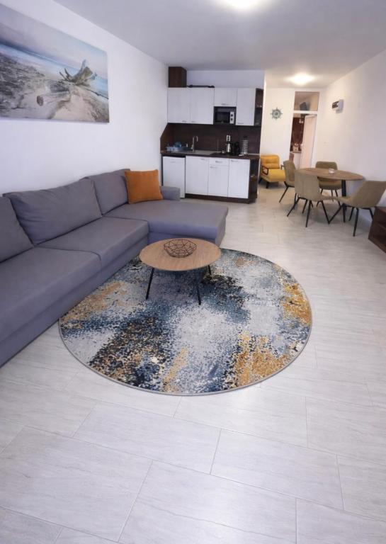 a living room with a couch and a table at Апартамент Студио Endless Созопол in Sozopol
