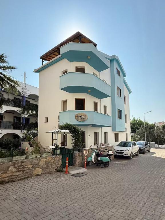 a large building with cars parked in a parking lot at Sahil Apart in Datca