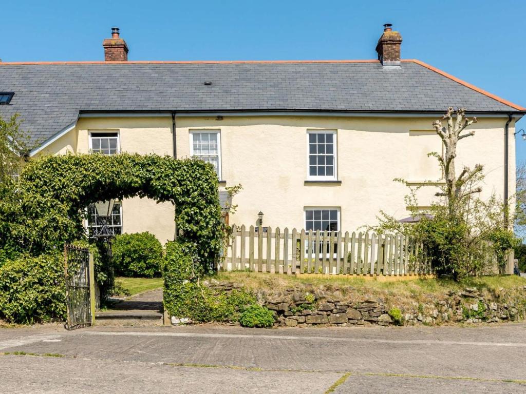 a white house with a fence and an arch at 1 Bed in Bideford oc-51784 in Parkham