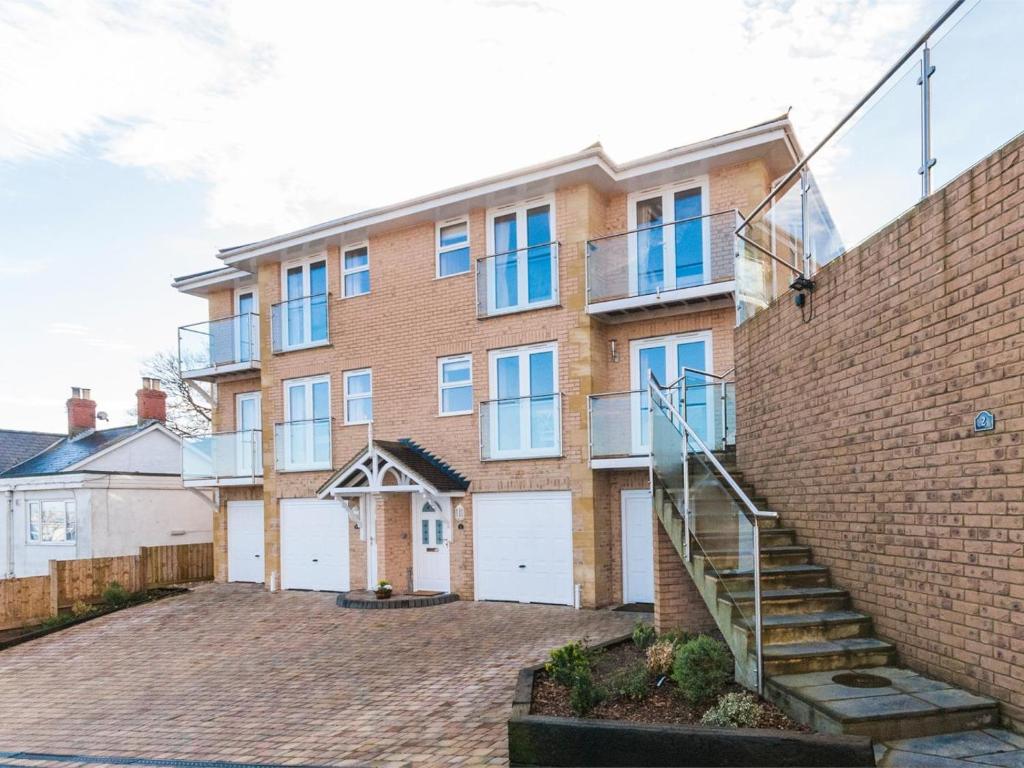 a brick building with white garage doors and a staircase at 3 Bed in Shanklin oc-ic113 in Shanklin