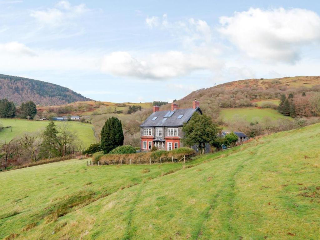 a house on a hill in a green field at 7 Bed in Machynlleth oc-77466 in Aberllefenni