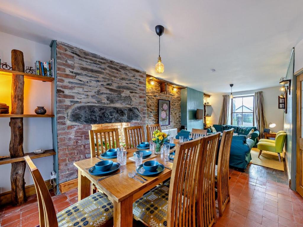 a dining room and living room with a brick wall at 4 Bed in Bala oc-94665 in Bala