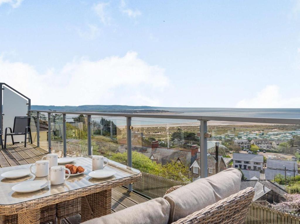 a balcony with a table and a view of the ocean at 4 Bed in Aberdovey oc-87586 in Aberdyfi