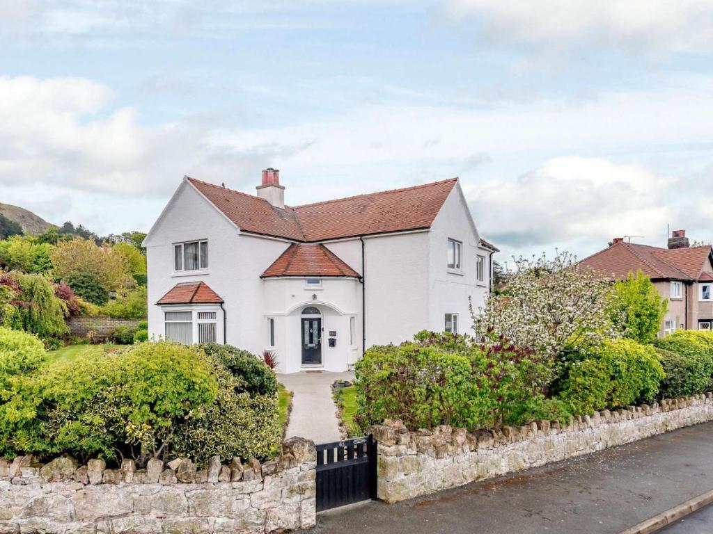 a white house with a red roof at 4 Bed in Llandudno oc-75466 in Llandudno