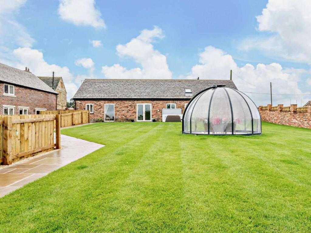 a garden with a greenhouse in front of a house at 2 Bed in Wakefield oc-93235 in Crofton