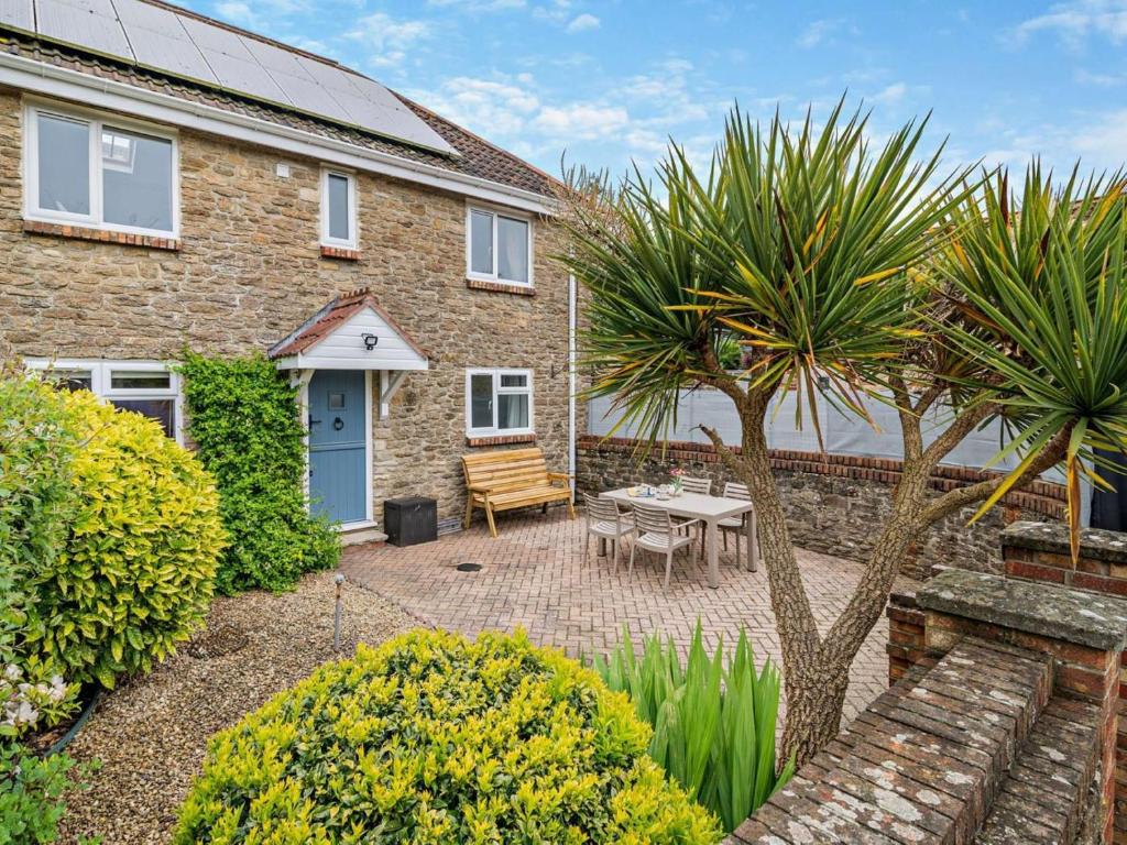 a brick house with a patio and a table at 2 Bed in Bridport oc-94222 in Bridport