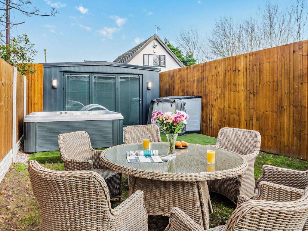 a patio with a table and chairs and a tub at 2 Bed in Rhyl oc-94036 in Kinmel Bay