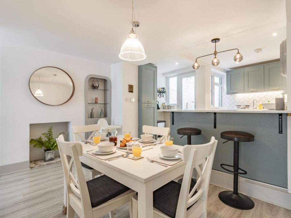 a kitchen and dining room with a white table and chairs at 3 Bed in Brixham oc-88116 in Brixham