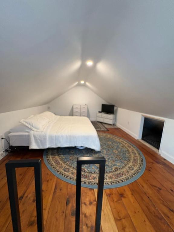 a bedroom with a bed and a rug on a wooden floor at Large King Suite Completely Private Space Stay close enough to Newport without the Noise in Portsmouth