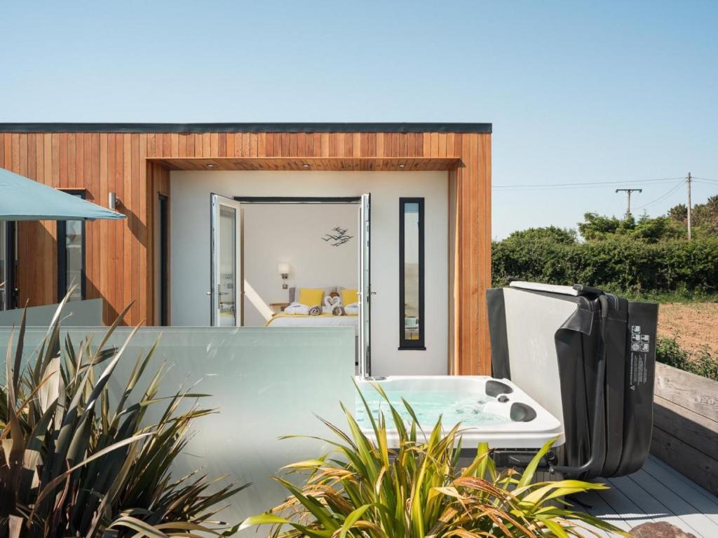 a small house with a tub on a deck at 1 Bed in Ilfracombe oc-52915 in Ilfracombe