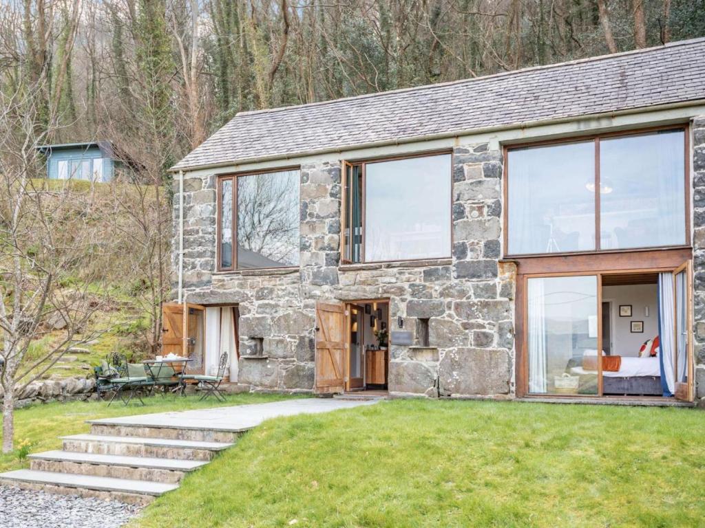 a stone house with glass doors and windows at 2 Bed in Arthog oc-66611 in Arthog