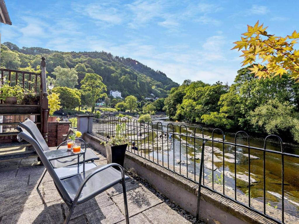 a balcony with a table and chairs overlooking a river at 1 Bed in Llangollen oc-92336 in Llangollen