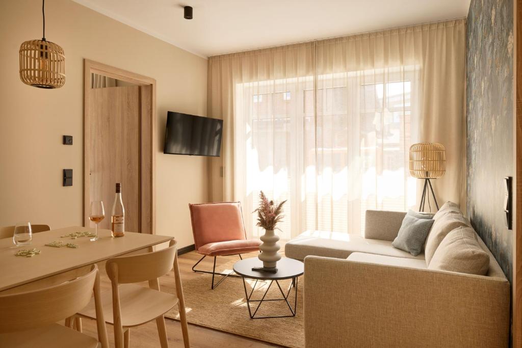 a living room with a couch and a table at Gezeiten Suites Büsum - Neueröffnung in Büsum