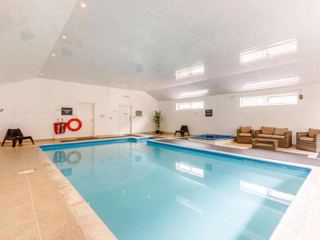 a large swimming pool with blue water in a building at 4 Bed in Ilfracombe oc-95899 in Berrynarbor