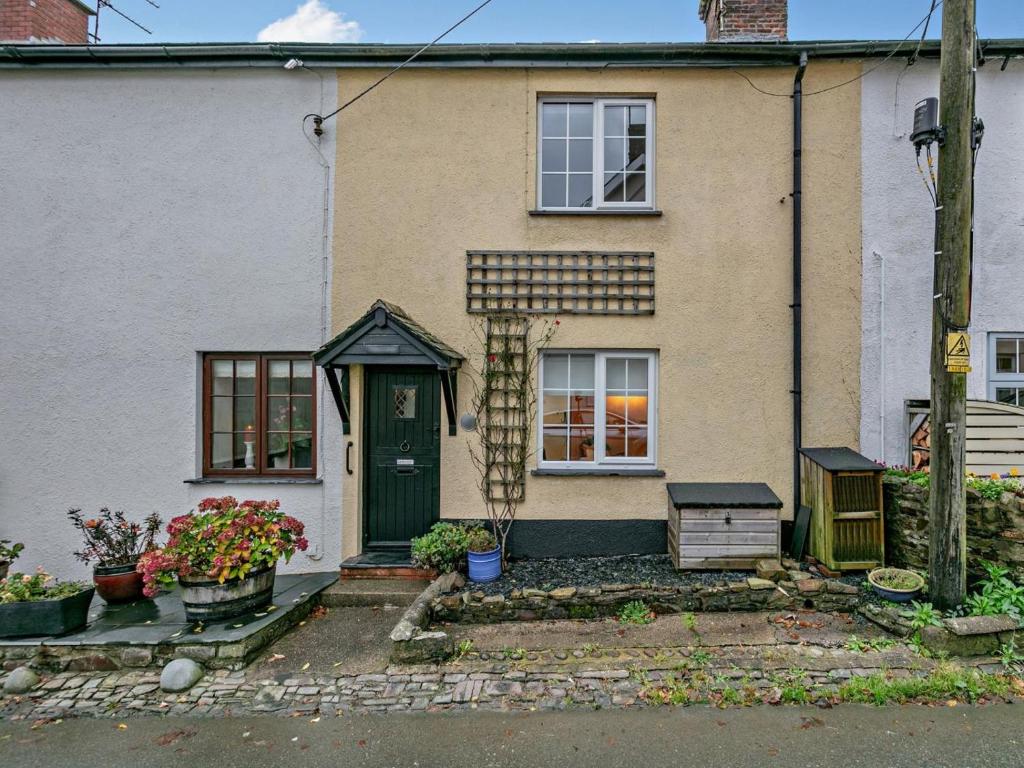 a house with a green door and flowers in front of it at 2 Bed in South Molton oc-55221 in Bishops Nympton
