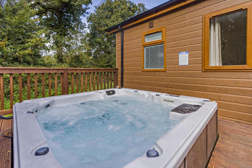 a hot tub on a deck next to a house at 2 Bed in Okehampton oc-85432 in Okehampton