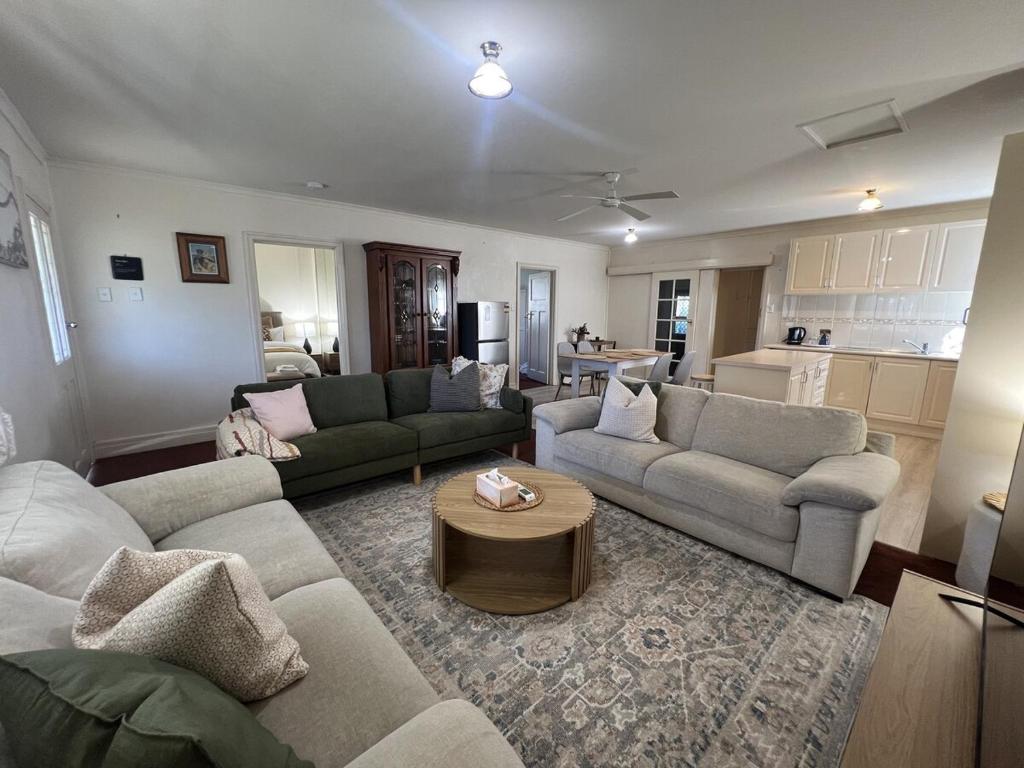 a living room with two couches and a table at Cosy Heritage Cottage in Ararat