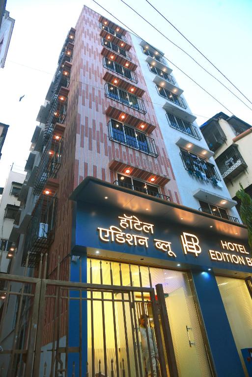 a tall building with a sign in front of it at Hotel Edition Blue in Mumbai