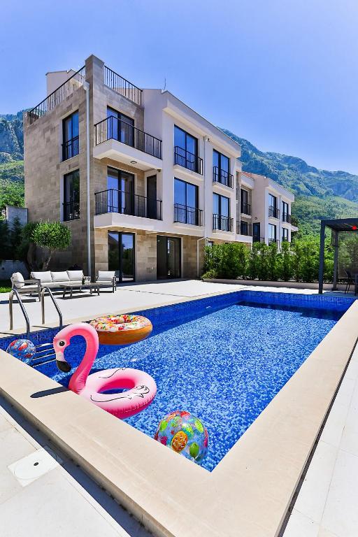 a swimming pool in front of a building at Poljana Olive Homes Pool Residences in Rijeka Reževići