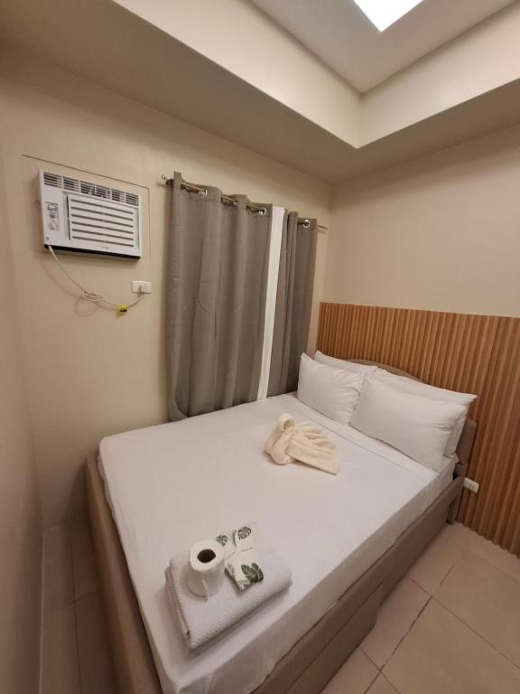 a bedroom with a bed with a air conditioner on it at Avida Storeys 2 7th Floor in Iloilo City