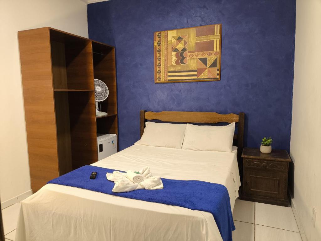 a bedroom with a bed with a blue wall at Hotel Villa Real in Diamantina