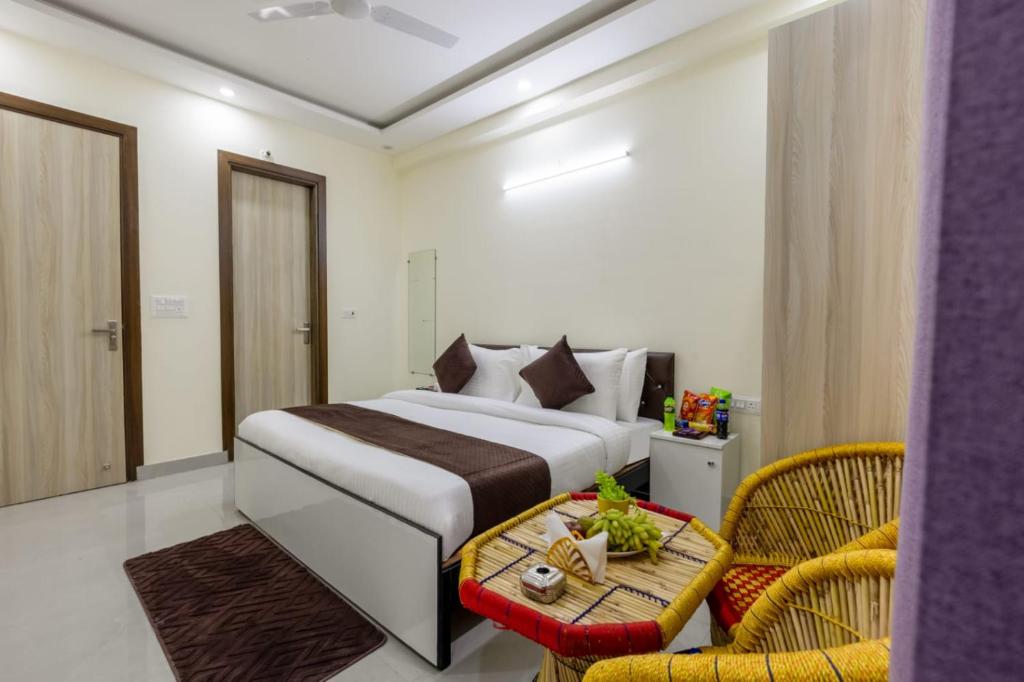 a bedroom with a bed and a table and a chair at Expressway Hotel - Yashobhoomi, Dwarka in New Delhi