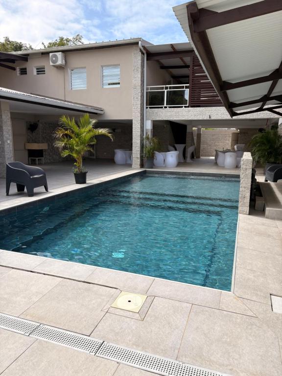 a swimming pool in front of a house at Relax Appart Hôtel in Kourou