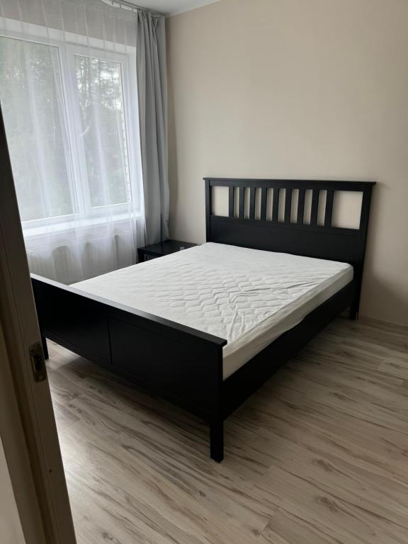 a bedroom with a bed in a room with a window at Straumes AP2 in Valmiera