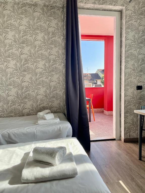 a room with two beds and a sliding glass door at Bnbook Residence La Red in Rho